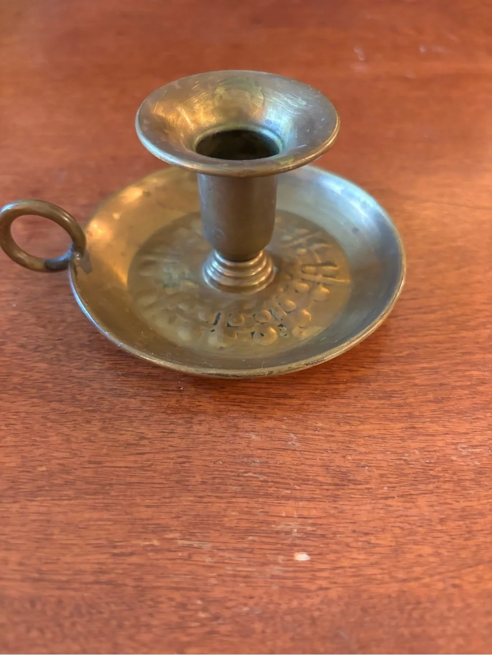 vintage brass chamberstick candle holder with a circular base and a ring handle